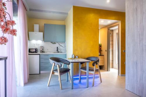 a small kitchen with a table and two chairs at La Rêve Luxury Apartments in Hersonissos