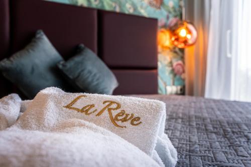 a bed with a towel with the word la rene on it at La Rêve Luxury Apartments in Hersonissos