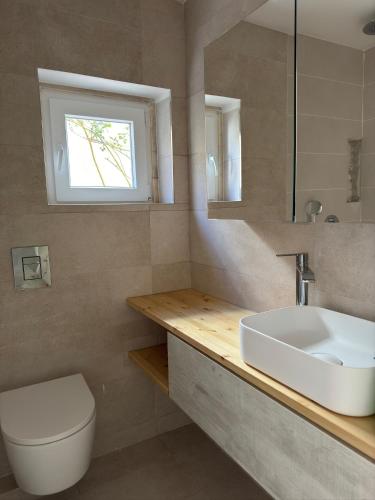 a bathroom with a sink and a toilet and a window at Villa Mave - Cascais in Estoril
