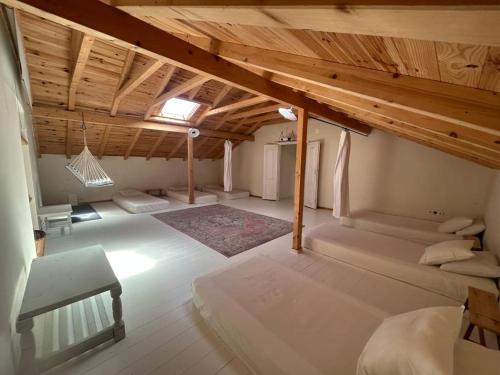 a attic room with two beds and a bench at Quinta Felicidade - Sea&Surf in Óbidos