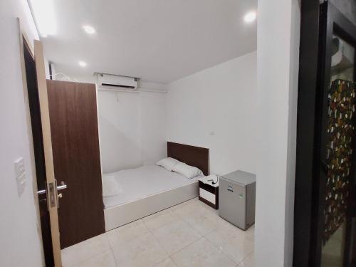a small white room with a small bed in it at Era Apartment Ham Long in Hanoi