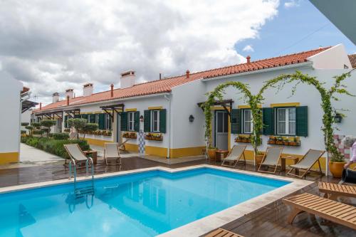a villa with a swimming pool and a house at Aposento Real Villas in Casa Branca