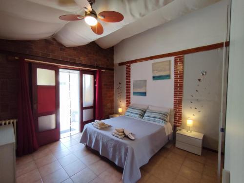 a bedroom with a bed and a ceiling fan at House Viareggio in Viareggio