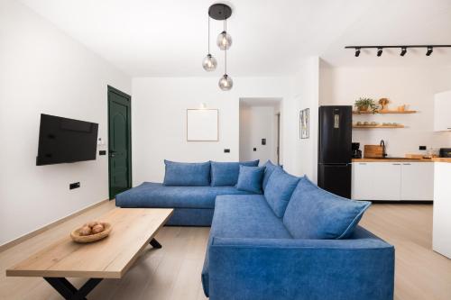 a living room with a blue couch and a table at Porta Verde Luxury Residence, By TK Property Management in Laganas