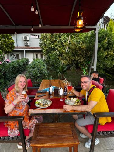a man and woman sitting at a table with food at Carmina Hotel in Ovacik