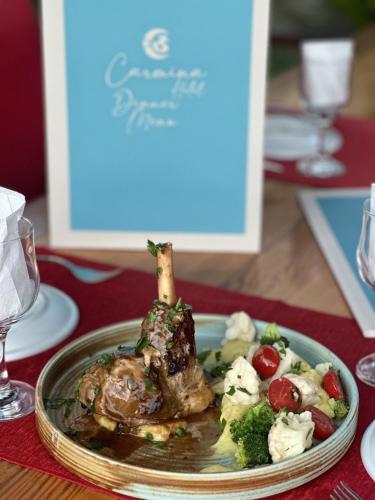 a plate of food with a piece of meat and vegetables at Carmina Hotel in Ovacik