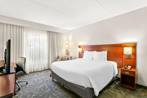 a hotel room with a large bed and a television at Sonesta Select Greenbelt College Park in Greenbelt