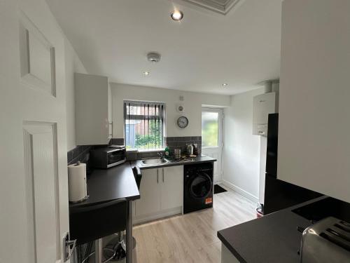 a kitchen with a sink and a stove at sark house Apartment Chorlton manchester in Manchester