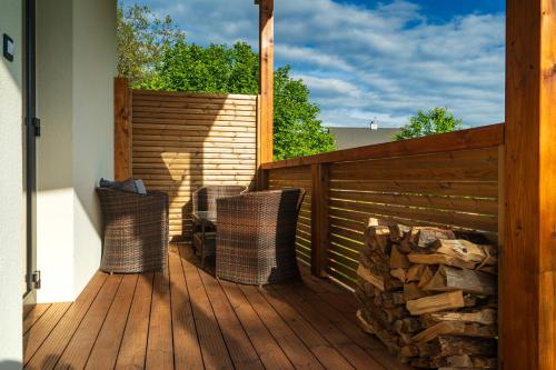 a wooden deck with two chairs and a fence at Relaxační domek "Na kraji Brd" in Hŭrky