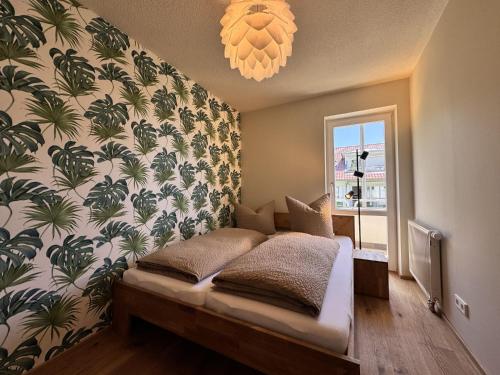 Un dormitorio con una cama y una pared con plantas. en Am Bodensee-Radweg, en Überlingen