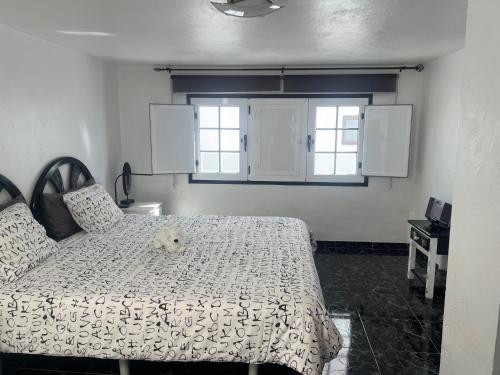 a bedroom with a bed with a teddy bear on it at Maison bord de mer Calypso in Punta Mujeres