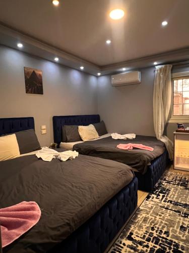 um quarto com 2 camas e um sofá em Aton pyramids INN no Cairo