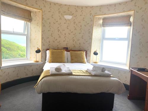 a bedroom with a large bed with towels on it at Tyr Graig Castle in Barmouth