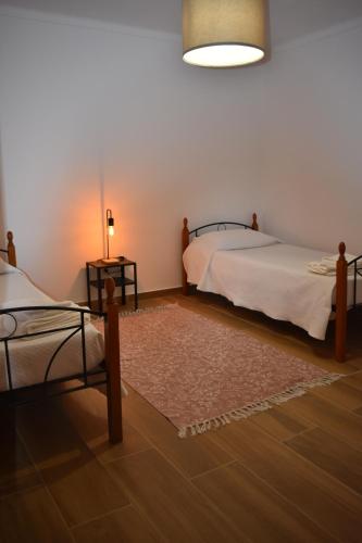 a bedroom with two beds and a rug at Casa da Espiga - Alentejo in Trigaches