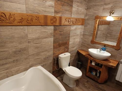 a bathroom with a tub and a toilet and a sink at Katilux willa in Nowy Targ