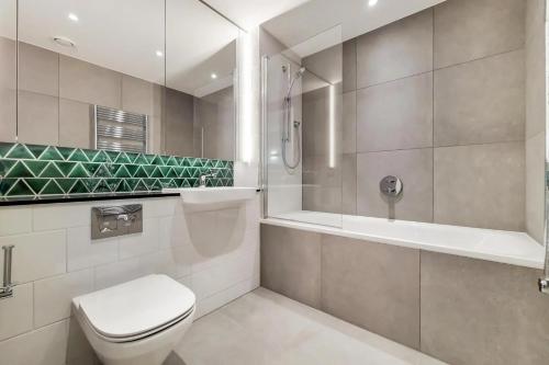 uma casa de banho com um WC, um chuveiro e uma banheira em Botanical-inspired apartments at Repton Gardens right in the heart of Wembley Park em Londres