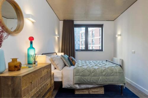 a bedroom with a bed and a couch and a mirror at Repton Gardens at Wembley Park in London