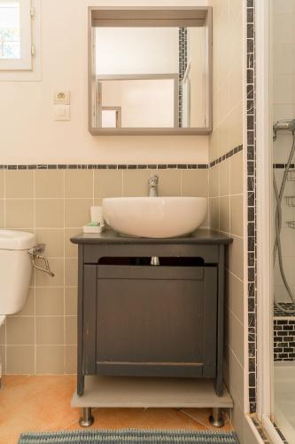 une salle de bain avec un lavabo et un miroir dans l'établissement Rez-de-villa à 15 minutes de Cassis, à Roquefort-la-Bédoule