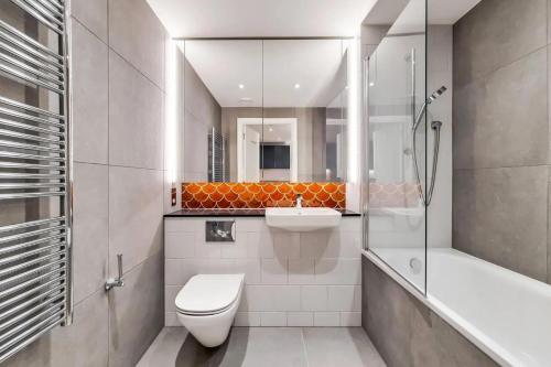 a bathroom with a toilet and a sink and a shower at Repton Gardens at Wembley Park in London