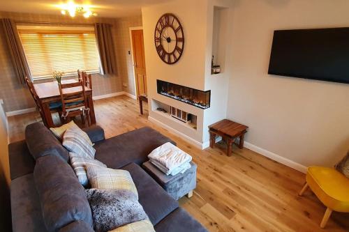 a living room with a couch and a flat screen tv at York Street Retreat, modern cosy 2 bed with garden in Dufftown