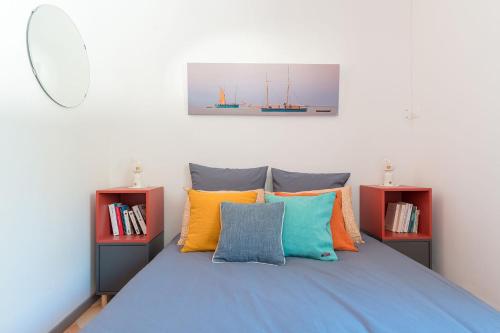 - une chambre avec un lit bleu et des oreillers colorés dans l'établissement Rez-de-villa à 15 minutes de Cassis, à Roquefort-la-Bédoule