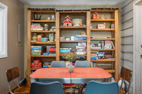 a table and chairs in a room with a book shelf at Lake Front-fishing-all sports Bass Lake Sanctuary in Traverse City