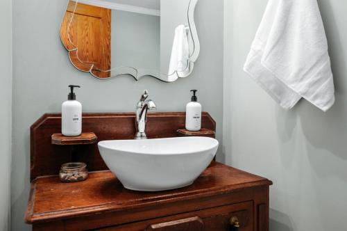 a bathroom with a white bowl sink and a mirror at Lake Front-fishing-all sports Bass Lake Sanctuary in Traverse City