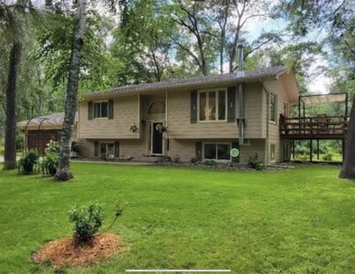 a house with a balcony and a yard at Large Home with lake views and space to entertain friends in Cross Lake
