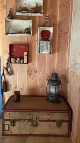 a room with a wooden wall with an old trunk at Chambre d'hôtes sous la canopée in Lanton