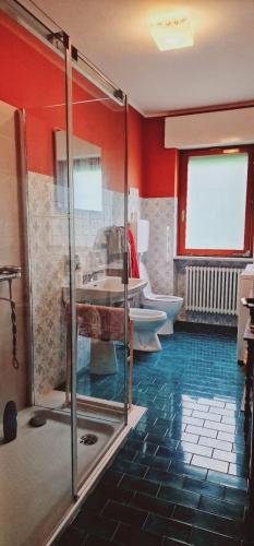 bagno con 2 servizi igienici e doccia in vetro di Villa Debora a Ponte nellʼAlpi