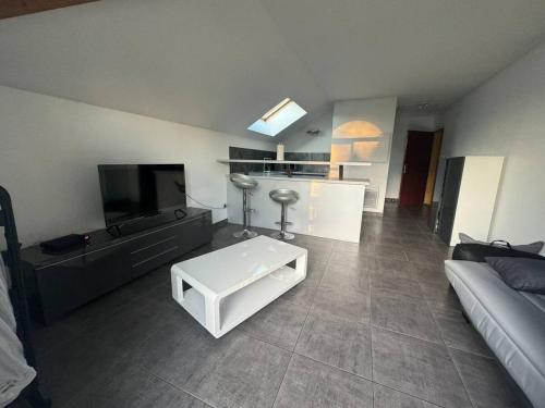 un salon avec un canapé et une télévision dans l'établissement Modern'Studio, à Puiseux-en-France