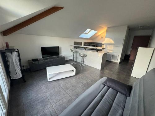 un salon avec un canapé et une cuisine dans l'établissement Modern'Studio, à Puiseux-en-France