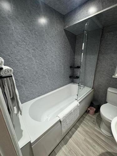 a bathroom with a bath tub and a toilet at Luxury Apartment in Ramsbottom