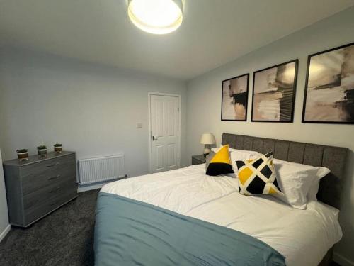 a bedroom with a bed and a dresser and pictures at Luxury Apartment in Ramsbottom