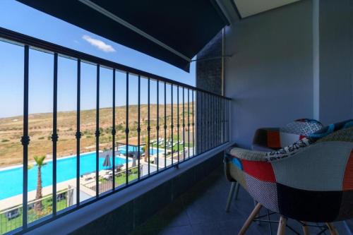 a balcony with a view of a swimming pool at Sophia village in Imouzzer Kandar