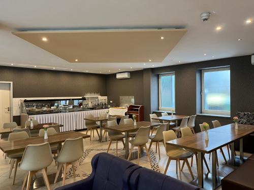 a restaurant with tables and chairs and a counter at Skyline Hotel Hannover in Hannover