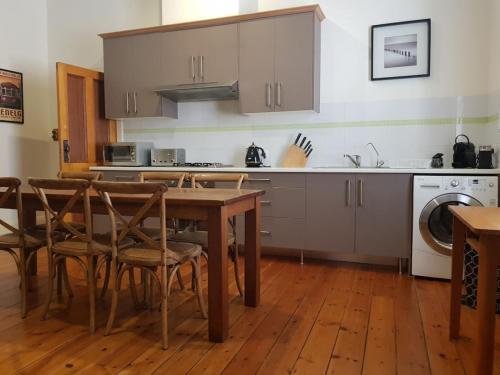 a kitchen with a table and chairs and a sink at The Heritage - located in in the center of Glenelg in Glenelg