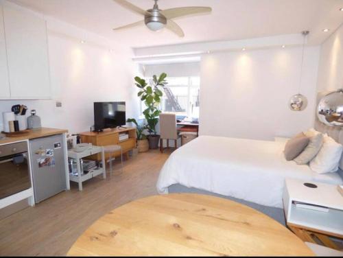 a bedroom with a bed and a kitchen with a table at Central Stylish Studio in Cape Town