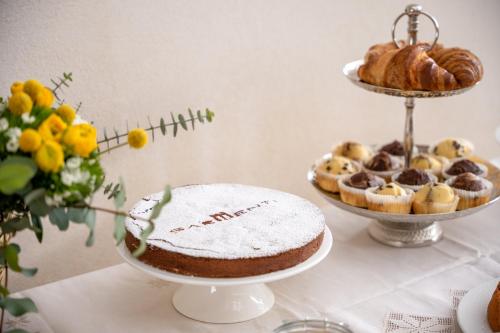 een tafel met daarop een taart en een bord met gebak bij Sarmenti Agriresort in Otranto