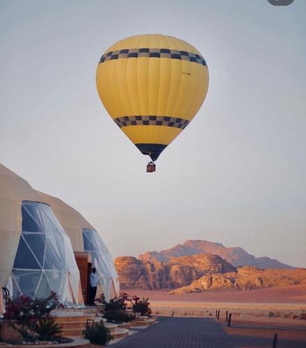 a hot air balloon flying over the desert at Orgoan camp wadirum in Disah