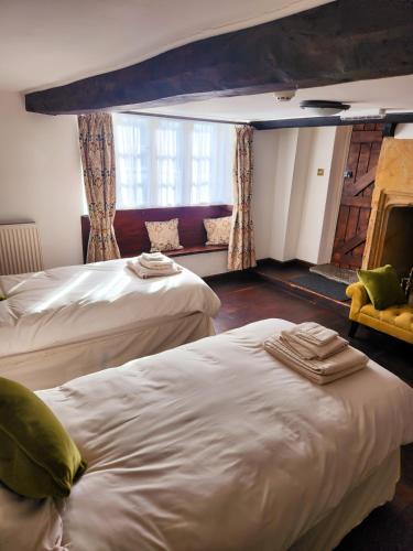 a hotel room with two beds and a window at The New Inn in Yeovil