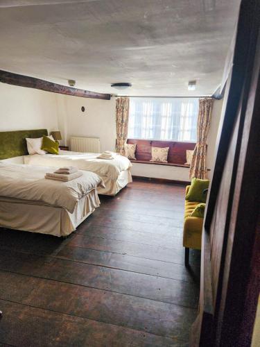 a hotel room with two beds and a window at The New Inn in Yeovil