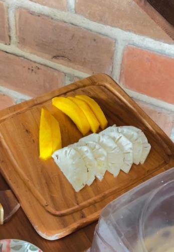 a wooden cutting board with peeled bananas and onions at Pousada Morada do Sol in Jericoacoara