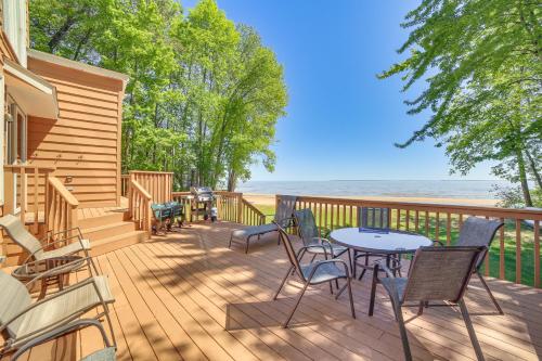 a deck with chairs and tables and the ocean at Private Beach and Deck Spacious Lake Michigan Home in Menominee