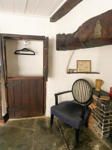 a chair sitting in a room with a door at The New Inn in Yeovil