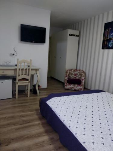 a bedroom with a bed and a desk and a chair at Randevu in Caracal