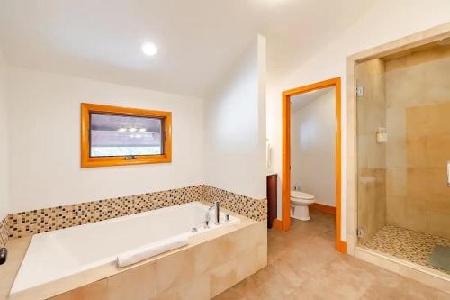 baño con bañera grande y aseo en Mountain View Cabin - Hot Tub - Sleeps 14 - 4 Bedrooms en Park City
