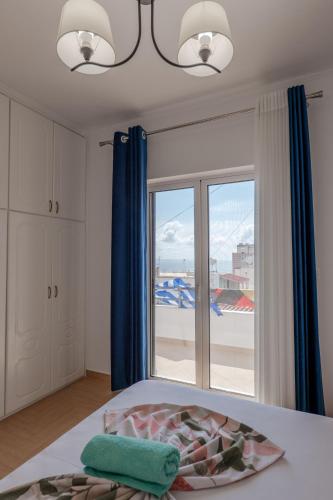 a bedroom with a bed and a large window at Hoteleks Inn & Suites in Sarandë