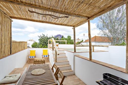 a balcony with a table and chairs and a grill at Casa dos Avos in Santa Luzia
