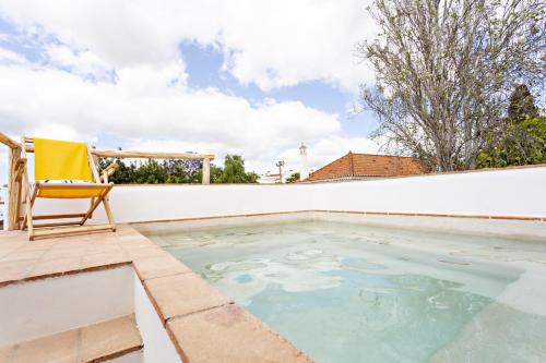 a swimming pool with a chair on a patio at Casa dos Avos in Santa Luzia